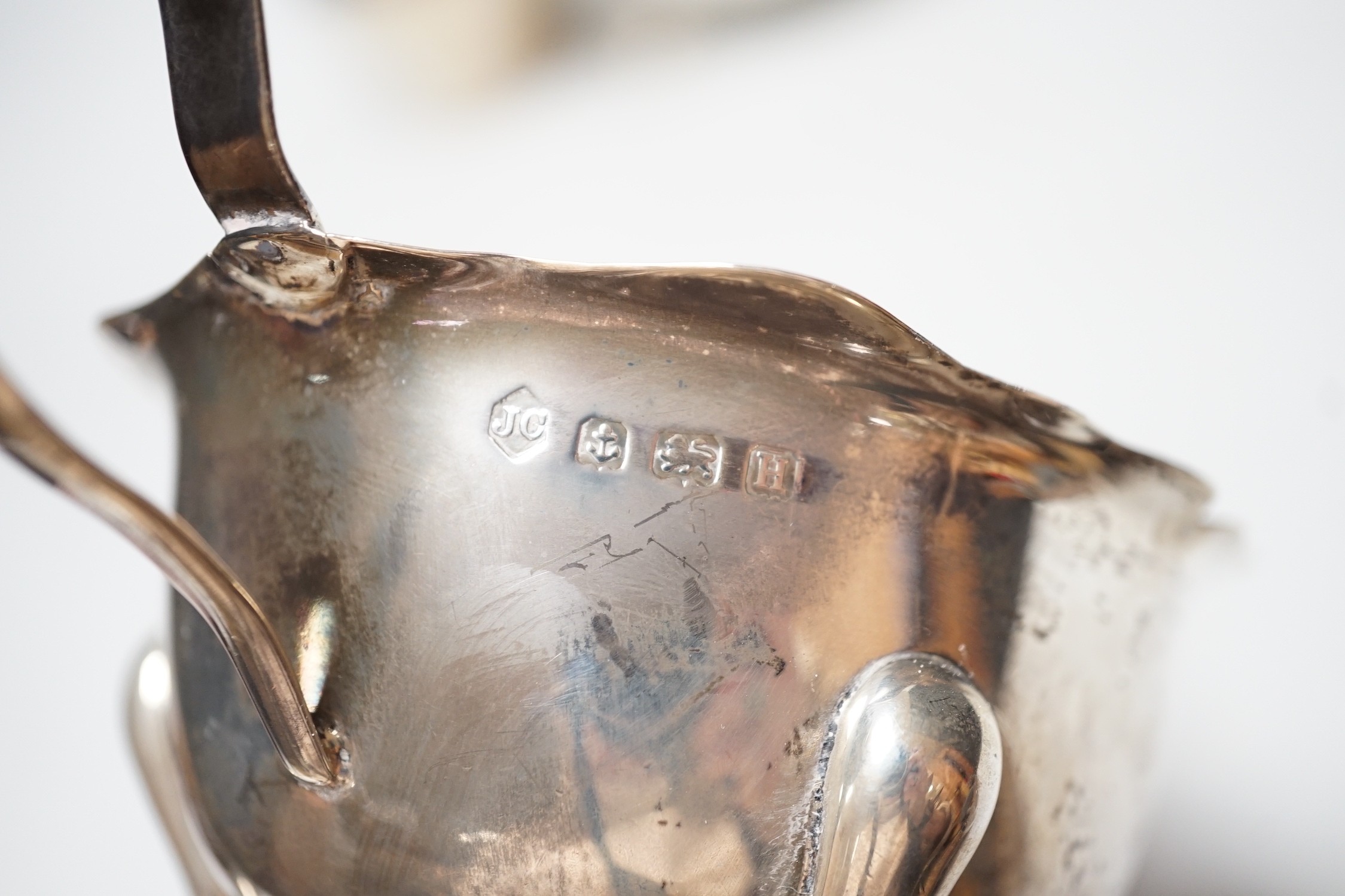 A George III silver cream jug, London, 1801, height 11cm, together with two later silver sauceboats, 10.9oz.